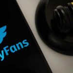 OnlyFans logo displayed on a smartphone next to a gavel