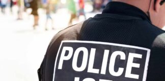 Close-up of a police officer's back with a 'POLICE ICE' badge