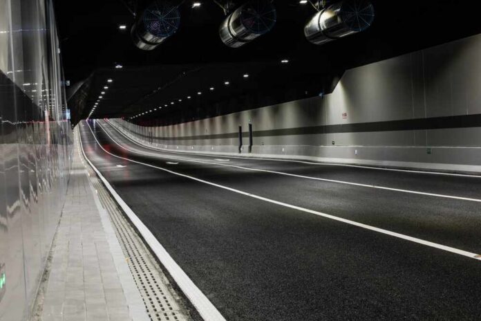 Interior view of a modern tunnel with illuminated road and ventilation systems