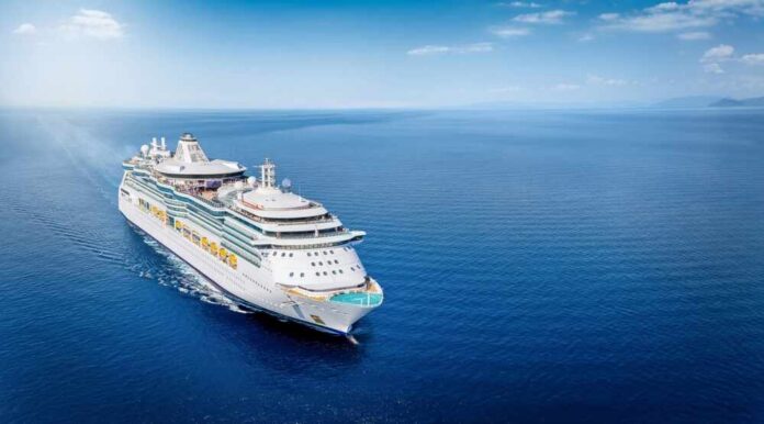 A large cruise ship sailing on a calm ocean under a clear blue sky