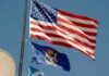 Michigan Campaign Turmoil: Unproven Fraud Claims Emerge American flag and Michigan state flag flying against a blue sky