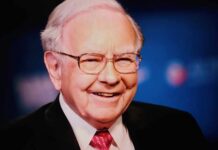 Smiling man in a suit with glasses against a blue background