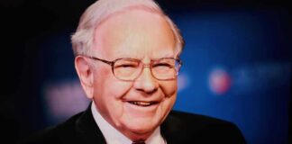 Smiling man in a suit with glasses against a blue background