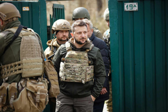 Man wearing tactical gear with military personnel around