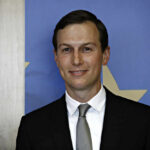 Man in suit with blue and star background.