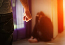 Person with clenched fist confronting a curled-up figure.