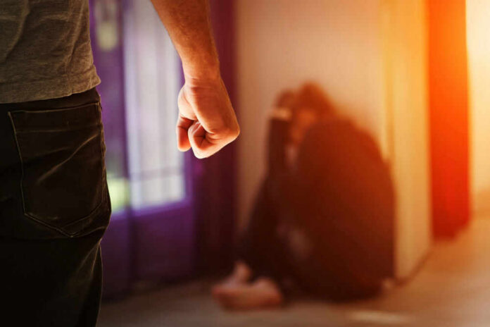 Person with clenched fist confronting a curled-up figure.