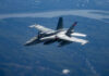 Military jet flying over mountainous landscape