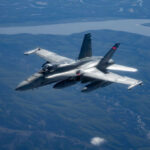 Rafale Fires Over Latvia—But Why? Military jet flying over mountainous landscape