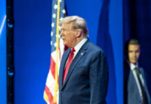 Man in suit with American flag background