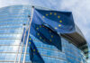 Aid Leverage Showdown: Sierra Leone On Edge European Union flags outside modern glass building