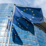 Aid Leverage Showdown: Sierra Leone On Edge European Union flags outside modern glass building
