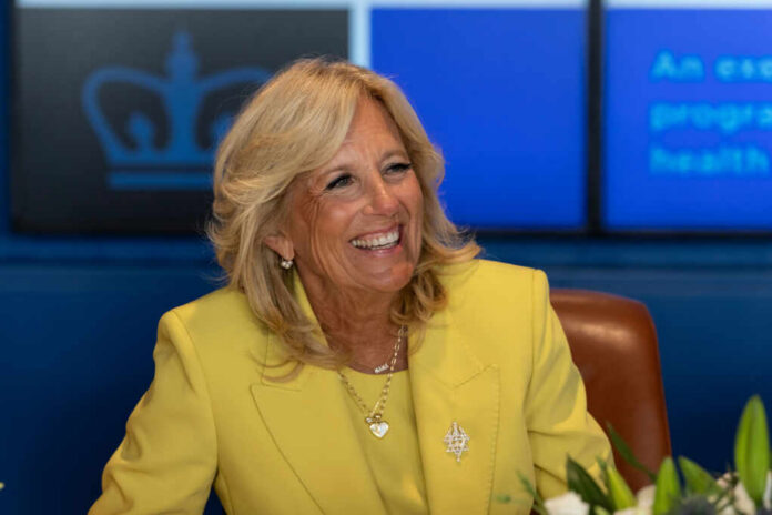 Smiling woman in a yellow blazer at a meeting table