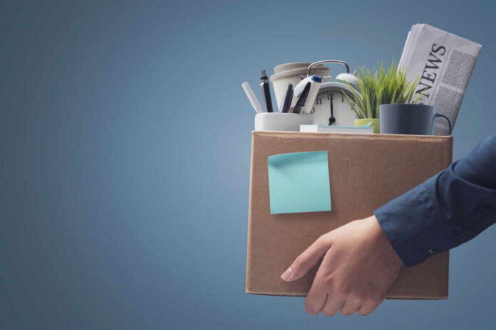 office-worker-carrying-personal-belongings2171747707jpg Person carrying a cardboard box of office supplies