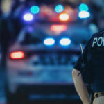 Bakersfield Bomb Scare, Dark Past Explodes Police officer standing near patrol car with lights