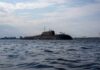 A submarine in the ocean with people on its surface