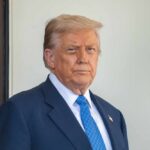 Weekend Deal Tease — What’s Trump Hiding? A political figure standing outdoors with a serious expression