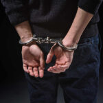 Person's hands cuffed behind their back