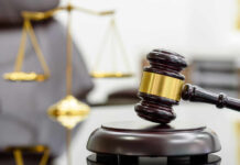 Justice Denied? Death Penalty Dropped A wooden gavel resting on a sound block with a blurred scale of justice in the background