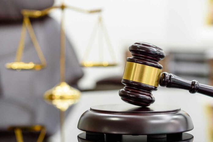 Legal,Office,Of,Lawyers,,Justice,And,Law,Concept,:,Wooden A wooden gavel resting on a sound block with a blurred scale of justice in the background