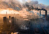 Industrial facility with smoking chimneys under a colorful sky