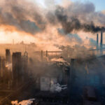 Petrochemical Lifeline Rocked — Fallout Hidden? Industrial facility with smoking chimneys under a colorful sky