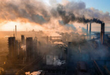 Petrochemical Lifeline Rocked — Fallout Hidden? Industrial facility with smoking chimneys under a colorful sky