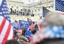 Capitol Chaos: FBI Numbers Don’t Add Up Crowd with flags near a government building