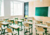 Empty classroom with desks facing a chalkboard