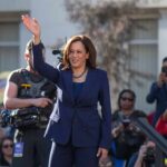 Top Democratic Donor Says Harris Can’t Win woman in navy suit waving at an outdoor event