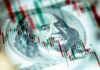 us dollar bill with stock candlestick chart overlay