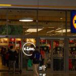 Entrance of a Lidl grocery store with customers shopping