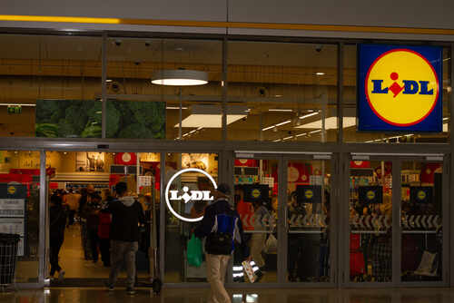 Entrance of a Lidl grocery store with customers shopping