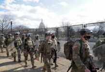 Congressman Challenges White House On War Powers Soldiers in riot gear patrol near a fenced government building