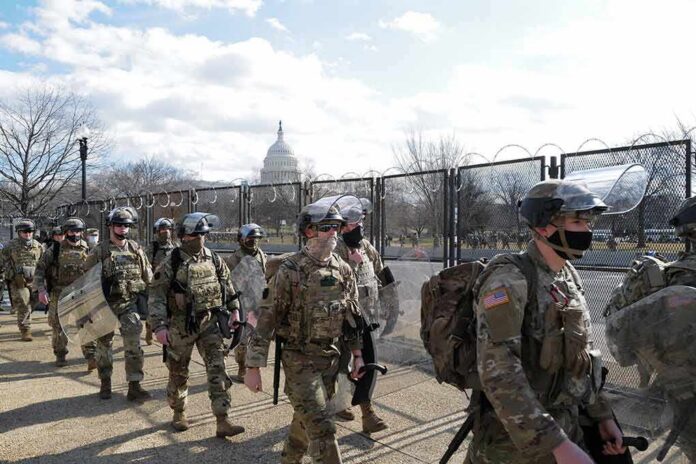 Soldiers in riot gear patrol near a fenced government building