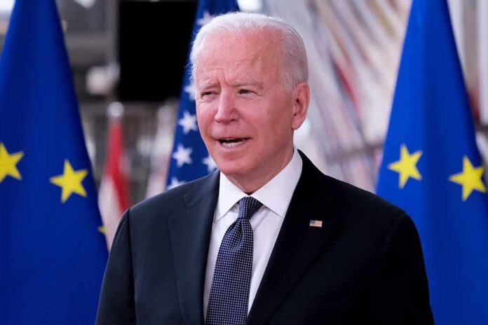 man in suit speaking between EU and US flags