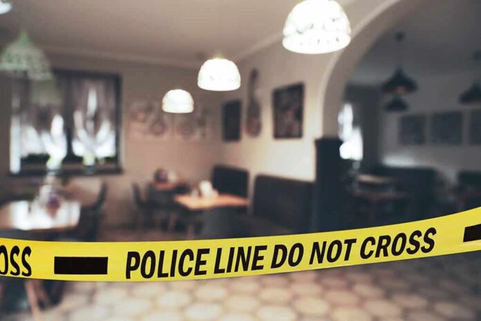 Police tape blocks entrance to a dimly lit restaurant interior