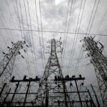 High-voltage transmission towers and power lines against a cloudy sky