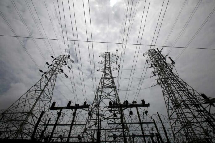 High-voltage transmission towers and power lines against a cloudy sky