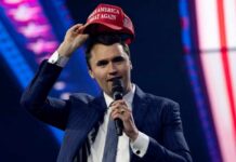 Second Shooter? Case-Blowing Twist Emerges Man in a suit holding a red cap while speaking into a microphone