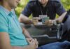 Police officer checks driver's license at car window