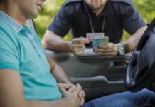 Police officer checks driver's license at car window