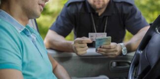 Police officer checks driver's license at car window