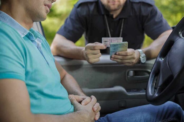 Police officer checks driver's license at car window