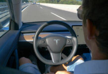 Person using autopilot in Tesla on highway.