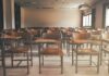 Empty classroom with rows of wooden desks and chairs
