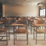 Kuwait Tightens Rules During Regional Crisis Empty classroom with rows of wooden desks and chairs
