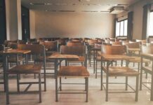 Empty classroom with rows of wooden desks and chairs