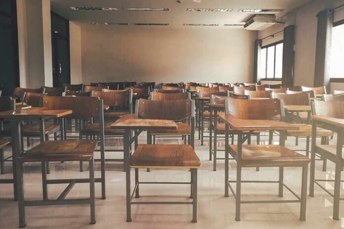 Empty classroom with rows of wooden desks and chairs