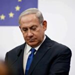 Hard No: Netanyahu Blasts US Gaza Plan man in suit at podium with EU flag in background